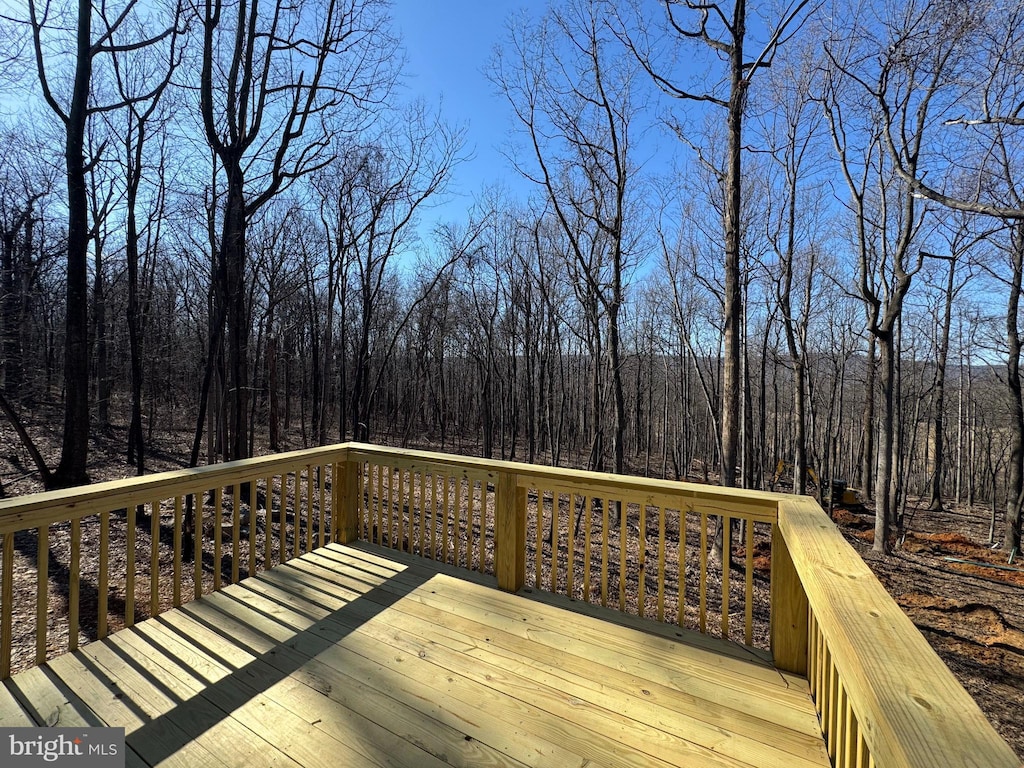 wooden deck featuring a forest view