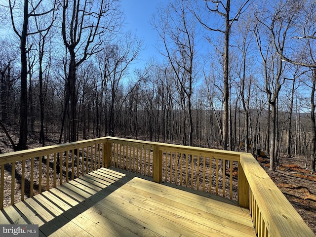 wooden deck featuring a forest view