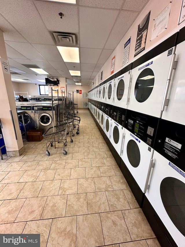 shared laundry area featuring independent washer and dryer, tile patterned floors, visible vents, and stacked washer and clothes dryer