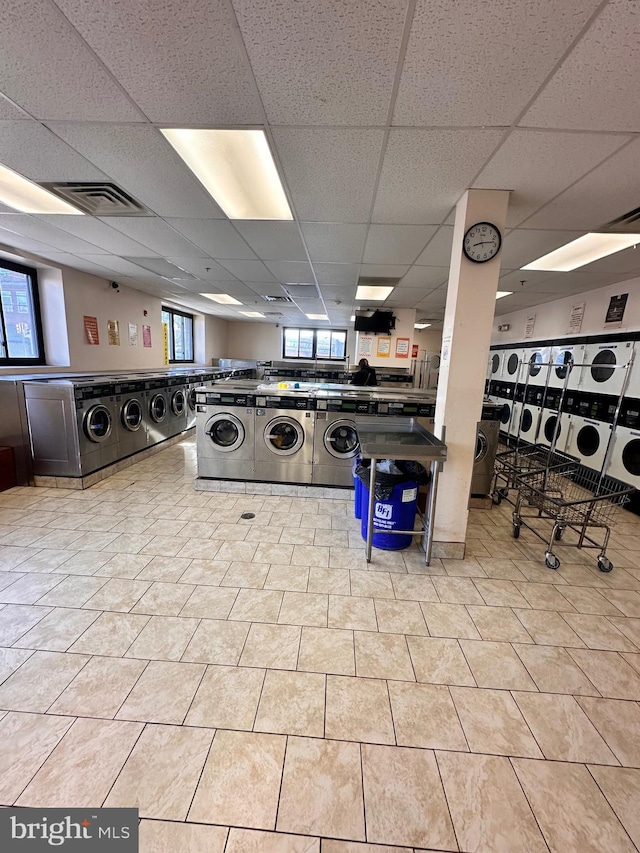 community laundry room featuring a healthy amount of sunlight, visible vents, stacked washer / drying machine, and independent washer and dryer