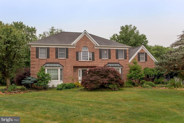 view of front of house featuring a front yard and brick siding