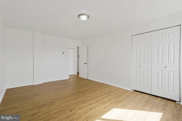 unfurnished bedroom featuring light wood-style floors and baseboards