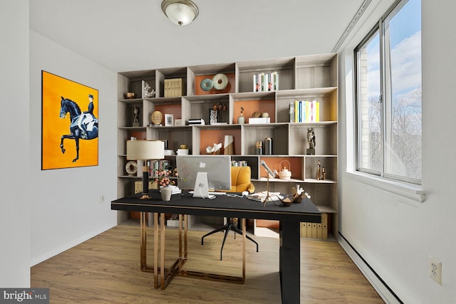 home office featuring a baseboard radiator and wood finished floors