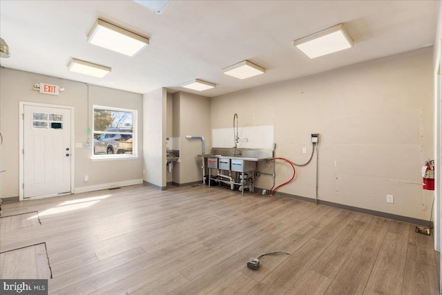 interior space featuring light wood-type flooring and baseboards