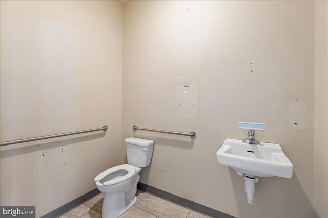 half bath featuring a sink, toilet, and baseboards