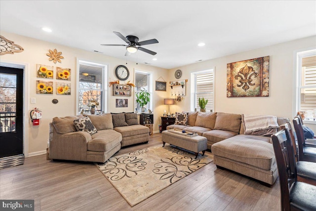 living area featuring light wood-style flooring, visible vents, baseboards, and recessed lighting