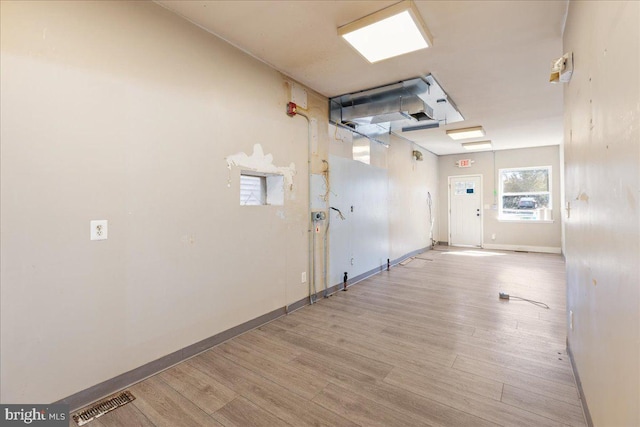 spare room with baseboards, visible vents, and wood finished floors