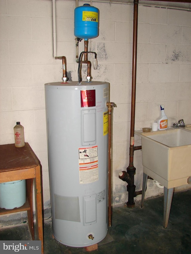 utility room with water heater and a sink