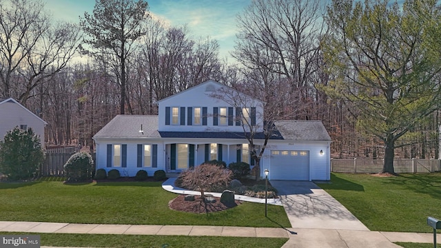 view of front of property featuring a front yard, concrete driveway, fence, and a garage