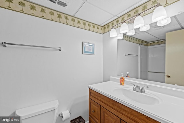 full bathroom featuring a paneled ceiling, toilet, visible vents, vanity, and a shower