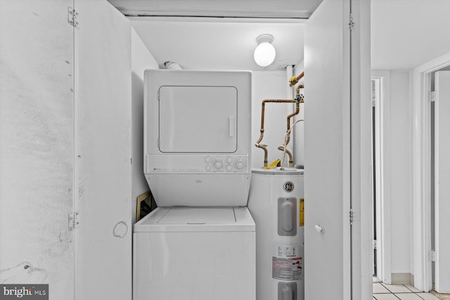 washroom with laundry area, stacked washer / drying machine, and electric water heater