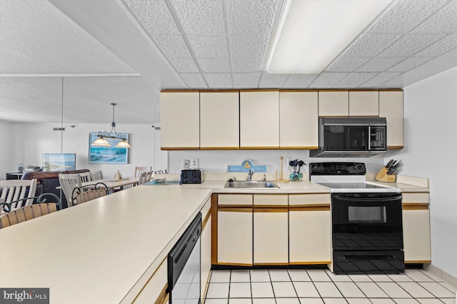 kitchen featuring light countertops, a sink, range with electric cooktop, black microwave, and dishwasher