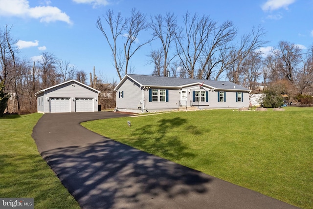 view of front facade featuring an outbuilding, a front yard, and a garage