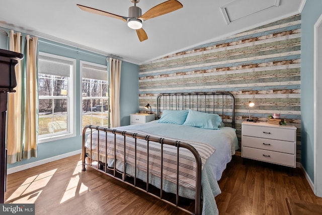 bedroom with lofted ceiling, wood finished floors, attic access, and baseboards