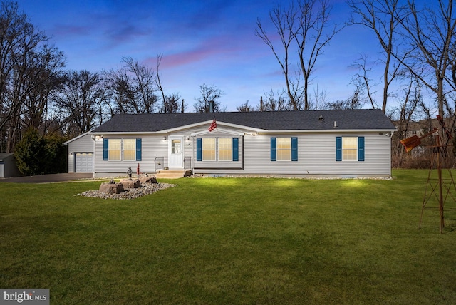 view of front facade featuring a garage, aphalt driveway, and a lawn