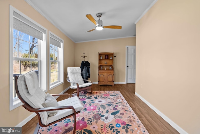 sitting room featuring ceiling fan, ornamental molding, wood finished floors, and baseboards