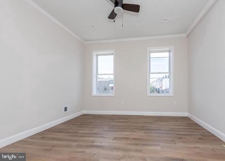 unfurnished room with ornamental molding, wood finished floors, a ceiling fan, and baseboards