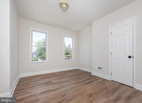 unfurnished room featuring baseboards and wood finished floors