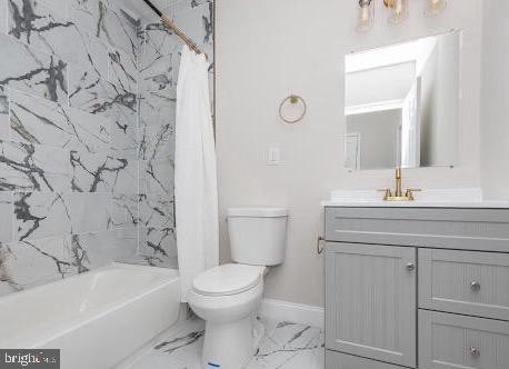 bathroom with toilet, vanity, baseboards, marble finish floor, and shower / bath combo with shower curtain