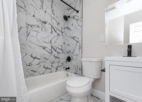 bathroom with marble finish floor, shower / bathtub combination with curtain, toilet, vanity, and baseboards