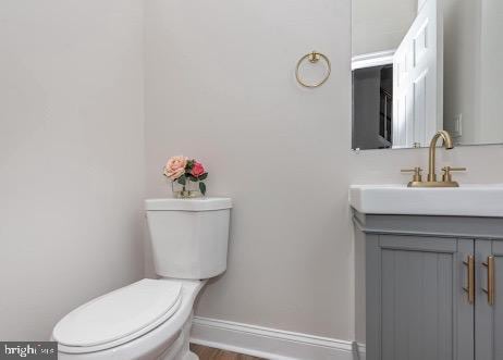 bathroom featuring vanity, toilet, and baseboards