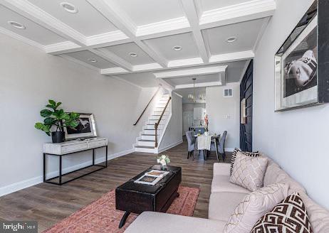 living area featuring baseboards, stairway, coffered ceiling, and wood finished floors