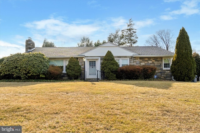 ranch-style house with a front yard, stone siding, and a chimney