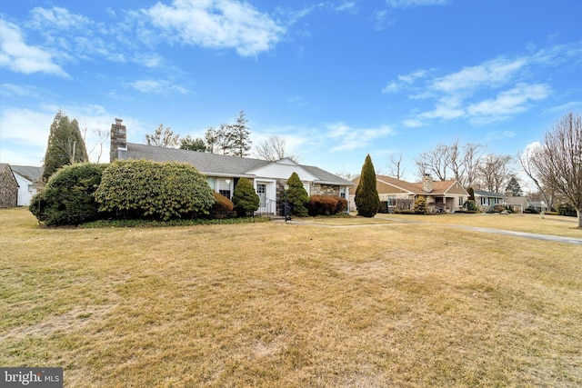 view of front of property with a chimney and a front yard