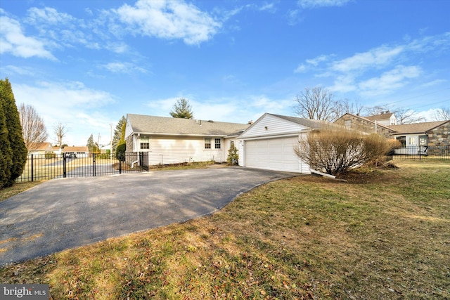 ranch-style house featuring driveway, a garage, fence, and a front yard