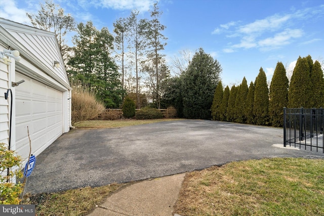 view of patio / terrace featuring driveway, a garage, and fence