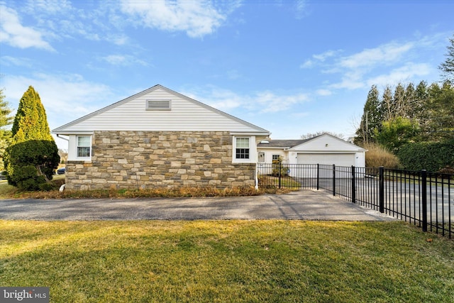 view of side of property featuring a garage, a yard, an outdoor structure, and fence