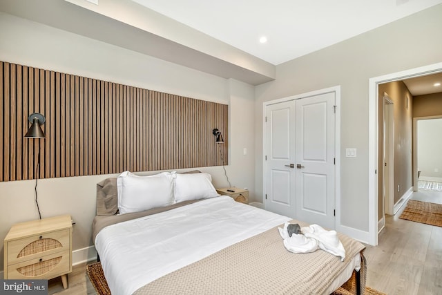 bedroom with light wood-style floors, baseboards, a closet, and recessed lighting