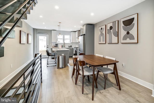 dining room featuring recessed lighting, light wood-type flooring, and baseboards