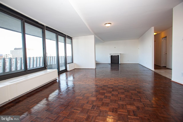 unfurnished room featuring baseboards and a fireplace