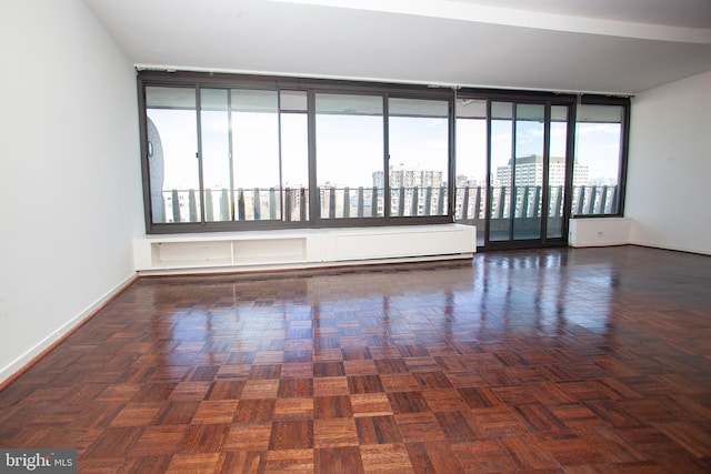 unfurnished room featuring a view of city and baseboards