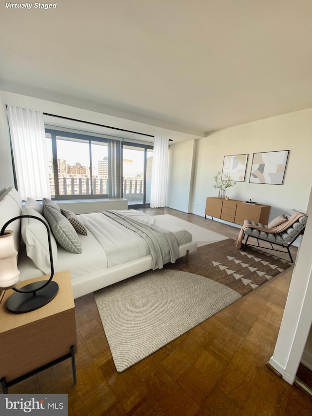 bedroom featuring a city view and multiple windows