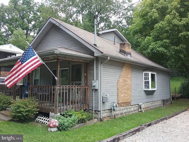 exterior space with roof with shingles and a chimney