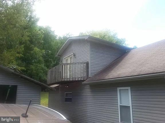 view of home's exterior featuring a balcony and a shingled roof