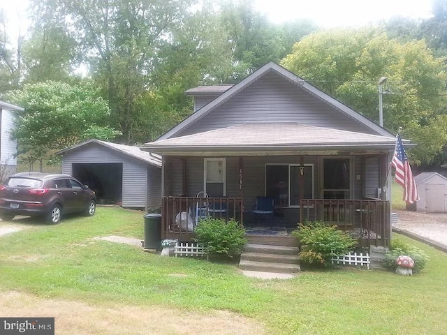 bungalow-style house with a garage, a front lawn, a porch, and an outdoor structure