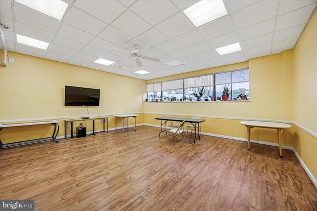 game room with ceiling fan, baseboards, a paneled ceiling, and wood finished floors