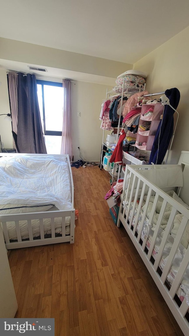 bedroom with visible vents and wood finished floors