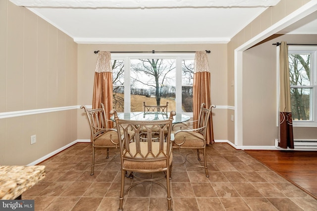 tiled dining space with a healthy amount of sunlight, baseboards, and ornamental molding