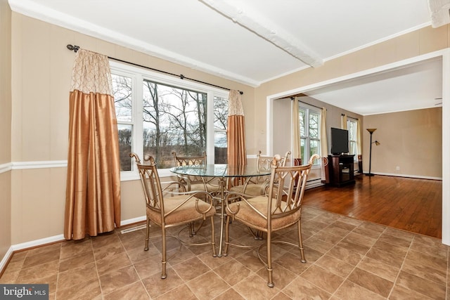 dining room with crown molding and baseboards