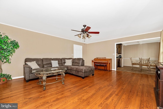 living room featuring wood finished floors, baseboards, and ceiling fan