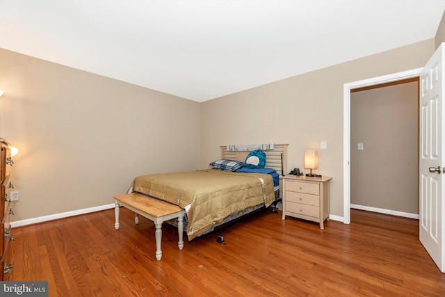 bedroom featuring baseboards and wood finished floors