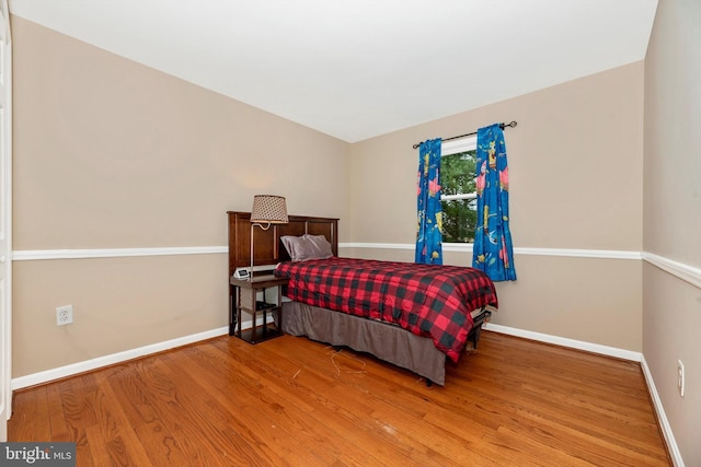 bedroom with baseboards and wood finished floors