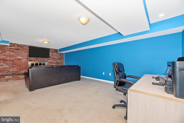 carpeted office space with brick wall, baseboards, and a brick fireplace