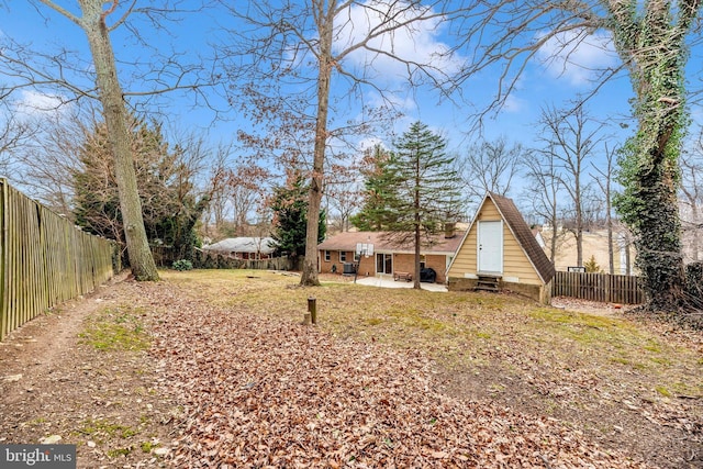 view of yard with entry steps, a patio, and a fenced backyard