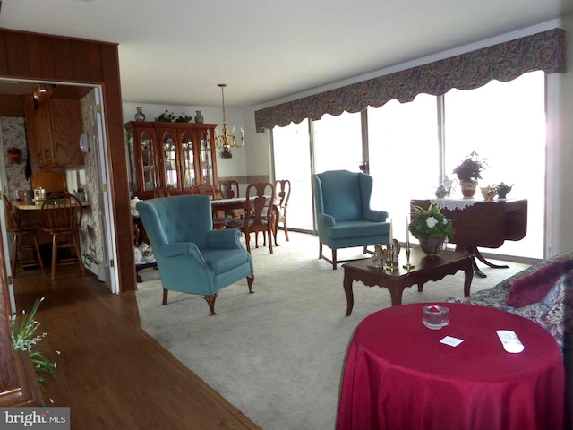 living room with an inviting chandelier, wood finished floors, and baseboard heating