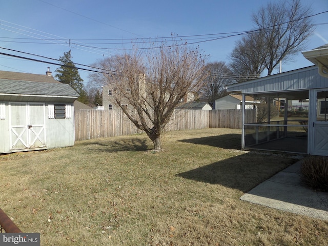 view of yard with an outbuilding, a fenced backyard, and a shed